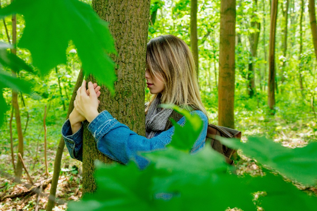 young-woman-with-backpack-hugging-tree-mixed-forest-beskidy-poland-spring-time.jpg