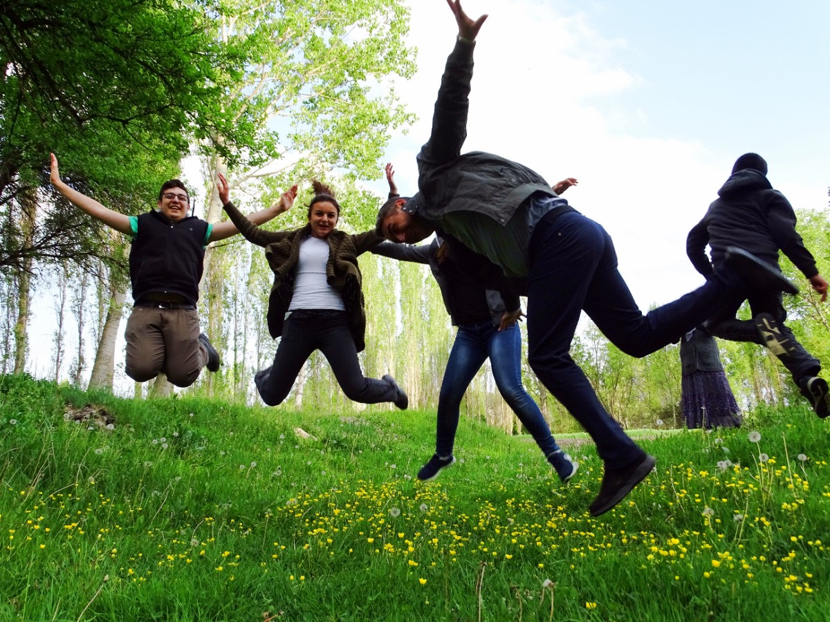 happy-friends-jumping-grassy-field-park.jpg
