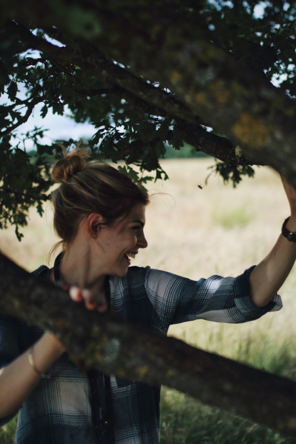 smiling-young-woman-holding-tree-branches.jpg